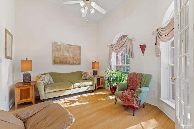 living room featuring wood-type flooring, french doors, ceiling fan, and ornamental molding