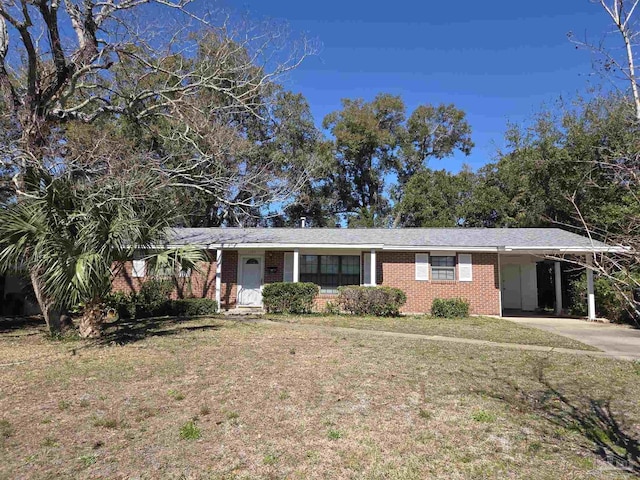 single story home featuring an attached carport, brick siding, driveway, and a front yard