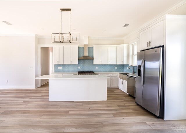 kitchen featuring appliances with stainless steel finishes, white cabinetry, a kitchen island, and decorative backsplash