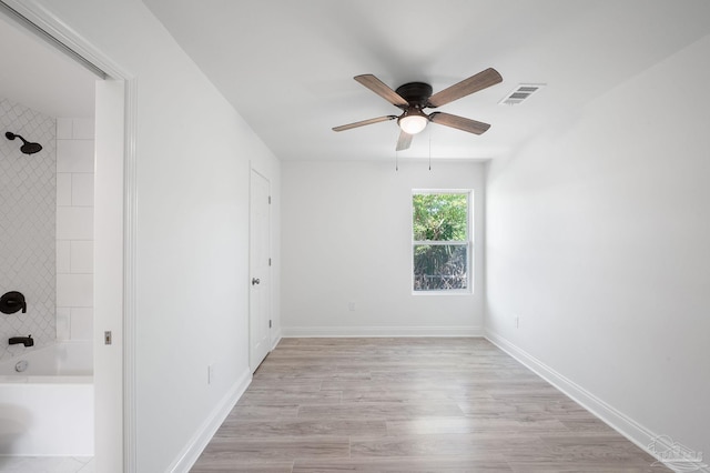 empty room with ceiling fan and light hardwood / wood-style flooring