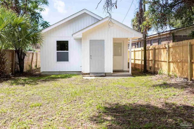 rear view of property with an outbuilding and a lawn