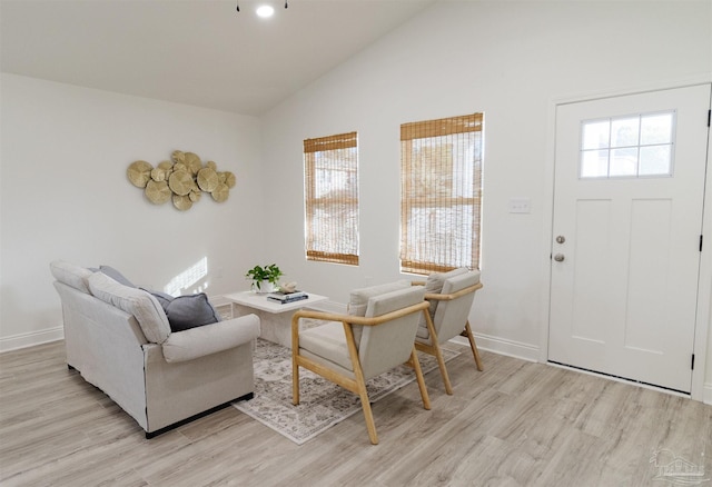 sitting room with high vaulted ceiling and light hardwood / wood-style floors