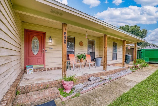 view of exterior entry featuring covered porch