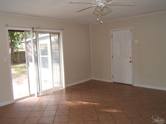 empty room with dark tile patterned flooring, crown molding, and ceiling fan