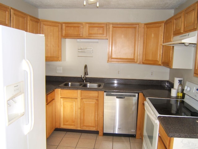 kitchen featuring white appliances, sink, a textured ceiling, and light tile patterned floors