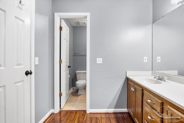 bathroom featuring vanity, toilet, and hardwood / wood-style flooring