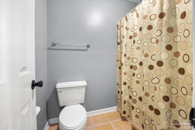 bathroom featuring curtained shower, toilet, and tile patterned floors