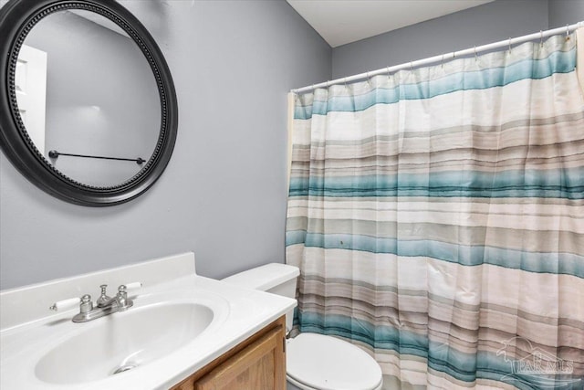 bathroom featuring walk in shower, vanity, and toilet