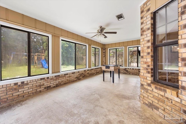 unfurnished sunroom with ceiling fan