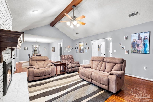 living room featuring a brick fireplace, vaulted ceiling with beams, ceiling fan, and hardwood / wood-style floors