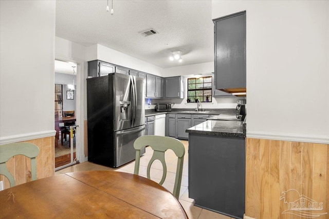 kitchen featuring white dishwasher, gray cabinets, a textured ceiling, sink, and stainless steel fridge with ice dispenser