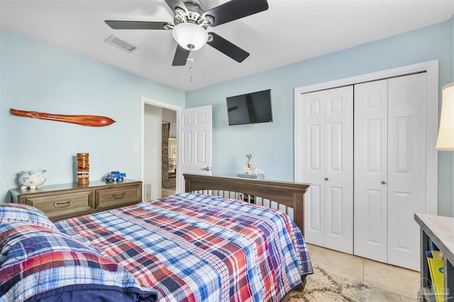 tiled bedroom with ceiling fan and a closet