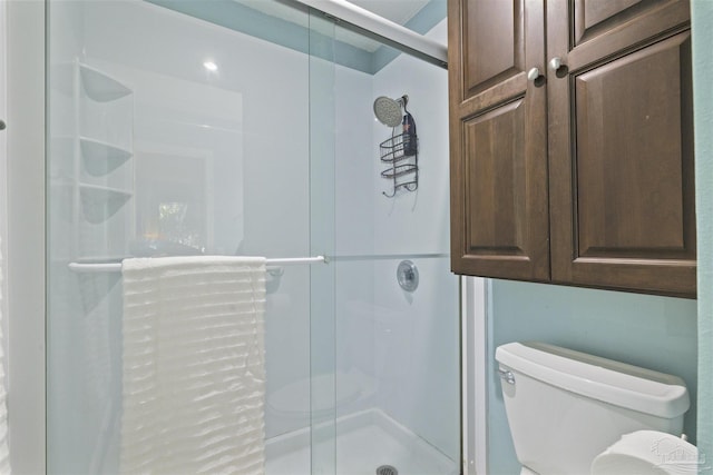 bathroom featuring an enclosed shower and toilet