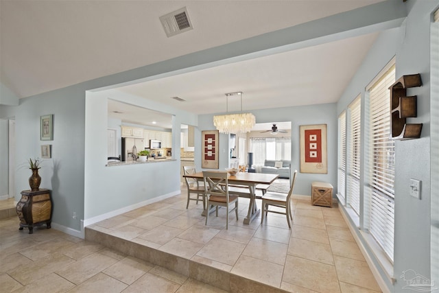 tiled dining area featuring ceiling fan with notable chandelier