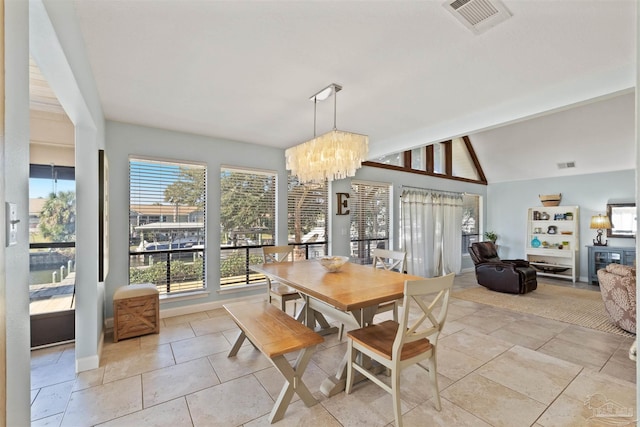 dining room featuring lofted ceiling with beams, plenty of natural light, and a notable chandelier