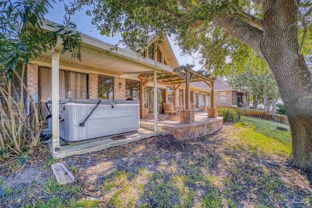 rear view of house with a patio and a hot tub