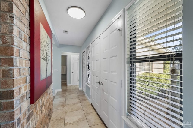 hall with light tile patterned floors