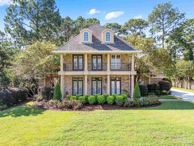 3869 Paradise Bay Dr, Gulf Breeze, FL 32563 - view of front of property with french doors, brick siding, a front yard, and a balcony