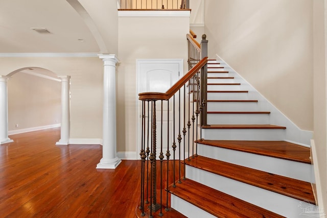 3869 Paradise Bay Dr, Gulf Breeze, FL 32563 - stairs with hardwood / wood-style flooring, decorative columns, arched walkways, crown molding, and baseboards