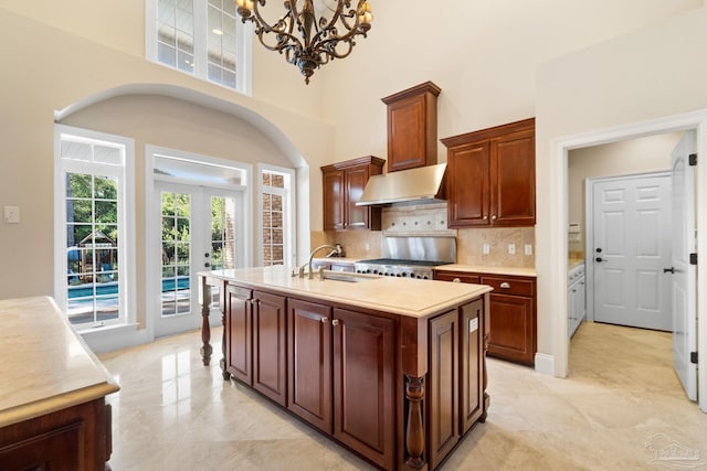 3869 Paradise Bay Dr, Gulf Breeze, FL 32563 - kitchen featuring a chandelier, light countertops, backsplash, a center island with sink, and a sink