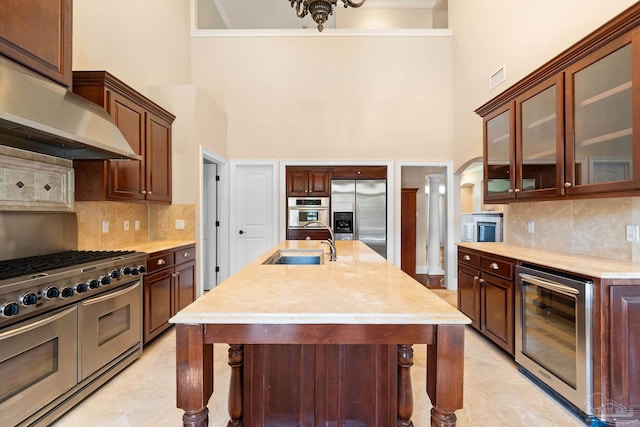 3869 Paradise Bay Dr, Gulf Breeze, FL 32563 - kitchen with appliances with stainless steel finishes, wine cooler, a high ceiling, a sink, and light countertops