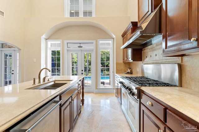 3869 Paradise Bay Dr, Gulf Breeze, FL 32563 - kitchen featuring a sink, stainless steel appliances, french doors, under cabinet range hood, and backsplash