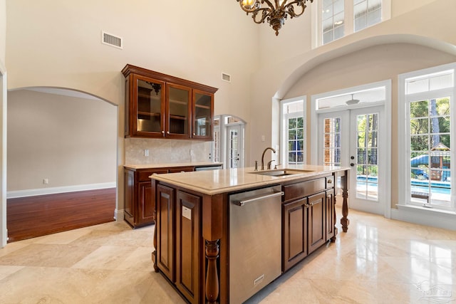 3869 Paradise Bay Dr, Gulf Breeze, FL 32563 - kitchen featuring arched walkways, stainless steel dishwasher, a sink, a high ceiling, and french doors