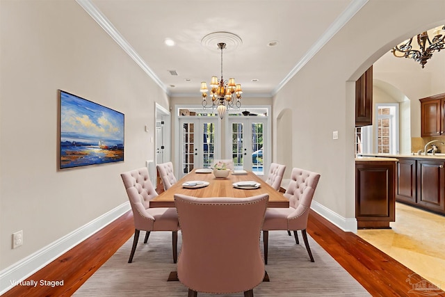 3869 Paradise Bay Dr, Gulf Breeze, FL 32563 - dining room with arched walkways, french doors, a chandelier, baseboards, and crown molding
