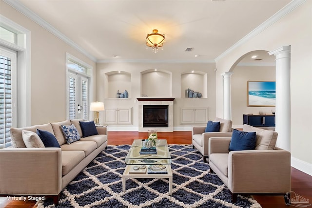 3869 Paradise Bay Dr, Gulf Breeze, FL 32563 - living room featuring decorative columns, arched walkways, wood finished floors, ornamental molding, and a glass covered fireplace