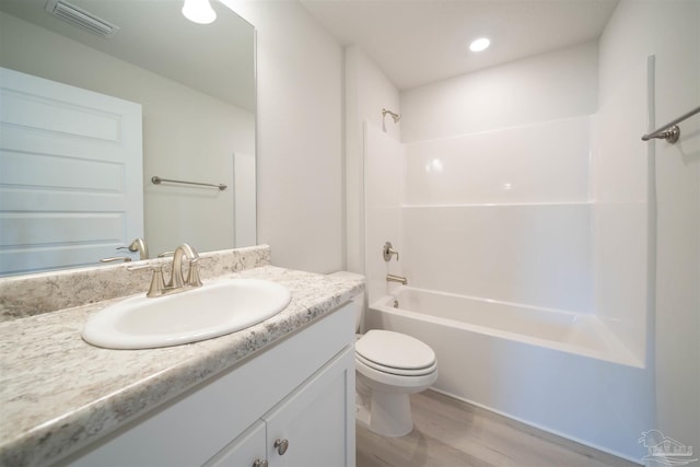 full bathroom featuring vanity, toilet,  shower combination, and hardwood / wood-style floors