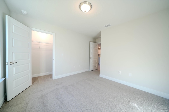 unfurnished bedroom with a closet and light carpet