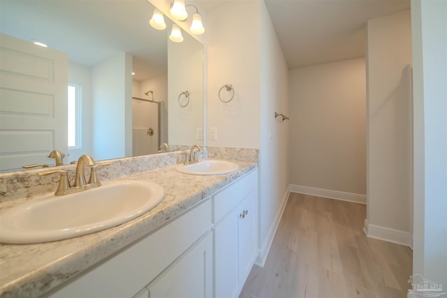 bathroom featuring hardwood / wood-style flooring, vanity, and walk in shower