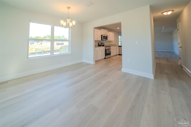 unfurnished living room with an inviting chandelier and light wood-type flooring