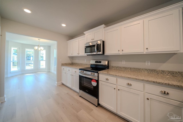 kitchen with a chandelier, light hardwood / wood-style flooring, appliances with stainless steel finishes, light stone countertops, and white cabinets