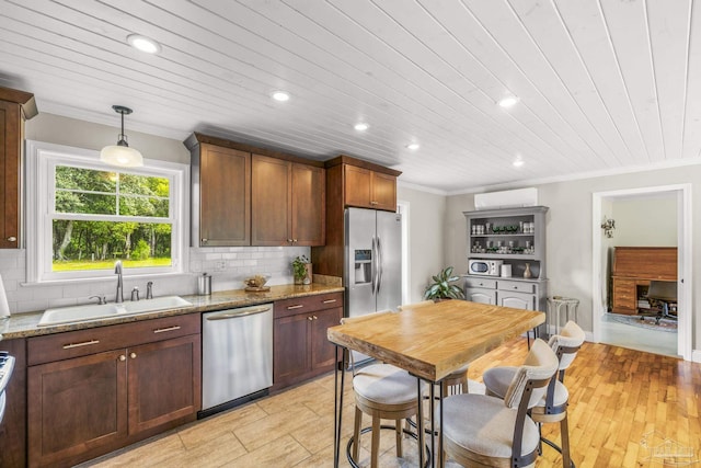 kitchen featuring decorative backsplash, ornamental molding, recessed lighting, a sink, and stainless steel appliances