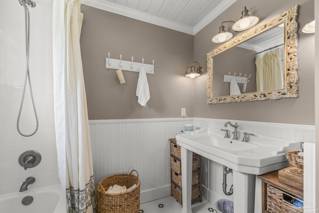full bathroom featuring crown molding, shower / bath combo with shower curtain, and wainscoting
