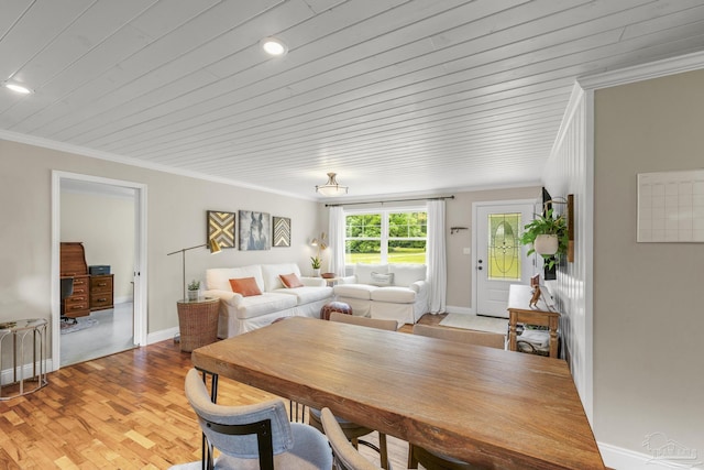 dining space featuring light wood-style floors, baseboards, ornamental molding, and wood ceiling