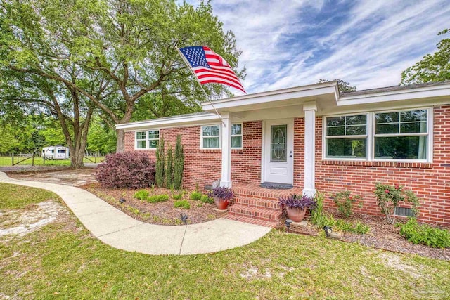 view of front of house featuring brick siding and a front lawn