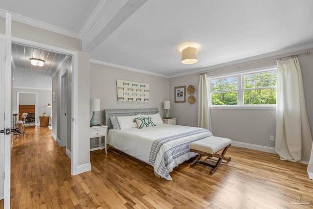 bedroom with baseboards, ornamental molding, and light wood-style flooring