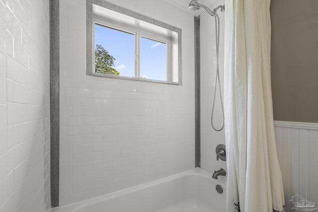 bathroom with wainscoting and shower / bath combination with curtain