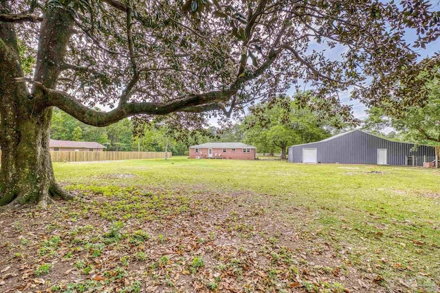 view of yard with fence, an outbuilding, an outdoor structure, and a garage