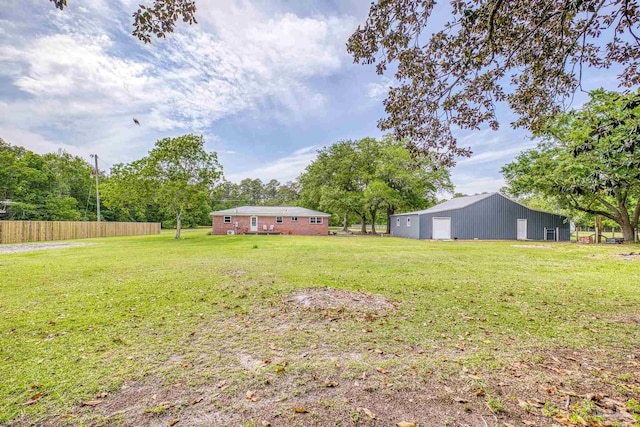 view of yard featuring fence, an outbuilding, and an outdoor structure