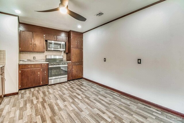 kitchen with visible vents, light wood finished floors, ceiling fan, and stainless steel appliances