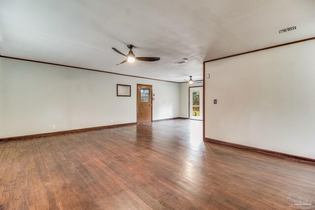 empty room with visible vents, ornamental molding, wood finished floors, baseboards, and a ceiling fan