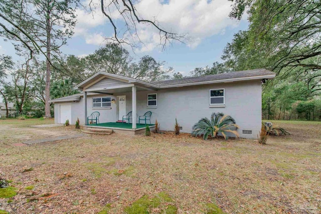 back of property featuring a garage, crawl space, covered porch, and a yard