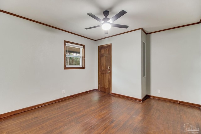 spare room with baseboards, dark wood-style floors, and ornamental molding