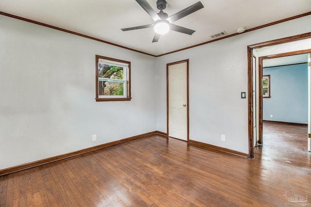 unfurnished bedroom with visible vents, ornamental molding, hardwood / wood-style floors, baseboards, and a ceiling fan