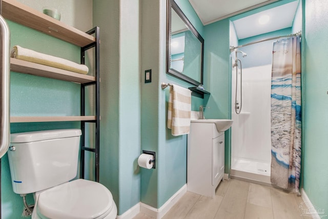 full bathroom featuring baseboards, vanity, toilet, and a shower stall