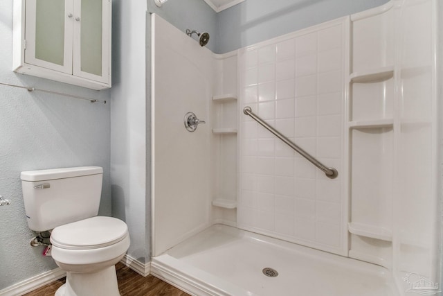 full bathroom featuring wood finished floors, a shower, and toilet