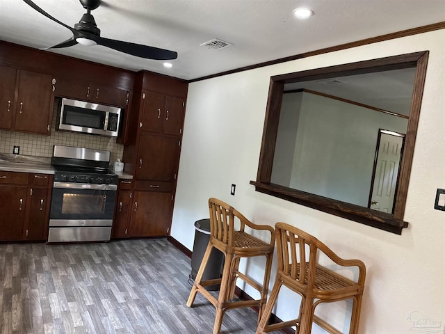 kitchen featuring ornamental molding, appliances with stainless steel finishes, tasteful backsplash, and ceiling fan